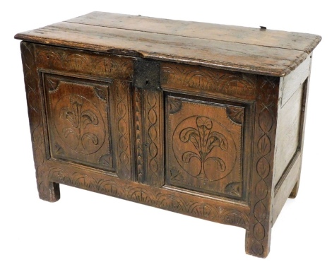 A 17thC and later carved oak blanket chest, with a two plank top, the front carved with two panels of Prince of Wales feathers raised on stile feet, 74cm high, 109cm wide, 54cm deep.