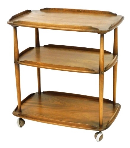 An Ercol light elm three tier trolley, raised on castors, 78cm high, 69cm wide, 45cm deep.