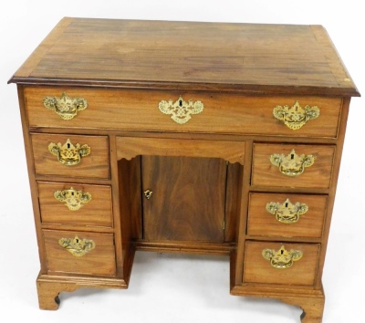 A Georgian mahogany kneehole desk, with one long frieze drawer, over a recess with semi secret drawer and cupboard below, flanked by six drawers, raised on bracket feet, 81cm high, 89cm wide, 51cm deep. - 2