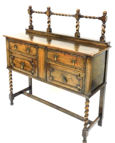 A 1920's oak sideboard, with a bobbin turned raised back, above two drawers and two panelled doors, on barley twist legs united by an H stretcher, 121cm wide.