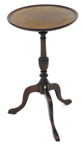 A Georgian style mahogany wine table, the circular top raised on a turned and fluted baluster column, over three cabriole legs, 66cm high, 38cm wide.