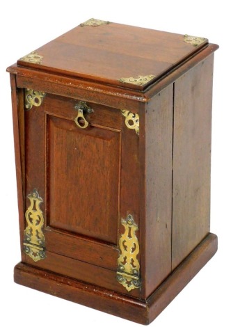 An early 20thC oak and brass coal purdonium, with panelled fall front door on a plinth, lacking shovel, 51cm x 32cm.