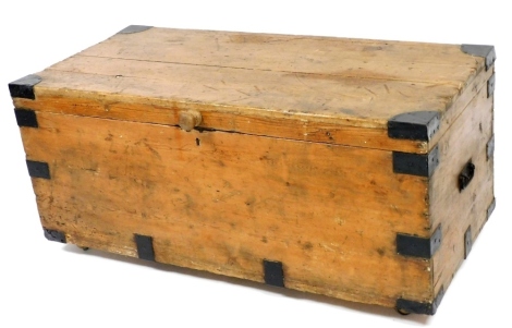 A Victorian pine and metal bound trunk, with later turned wooden handle, 54cm high, 119cm wide, 56cm deep.