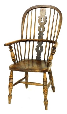 A 19thC beech and elm Windsor chair, with a carved splat, solid saddle seat, raised on turned legs united by an H framed stretcher, 59cm wide.