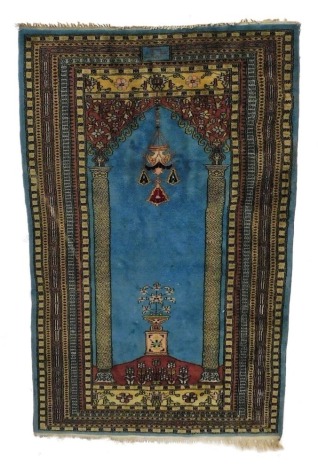 A Turkish blue ground prayer rug, decorated centrally with Mihrab and Mosque lamp, within multiple borders, 149cm x 94cm.