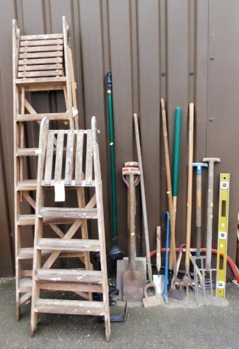 Two wooden A frame step ladders, various garden tools to include forks, spades, rake, shoe last, other tools, etc. (a quantity)