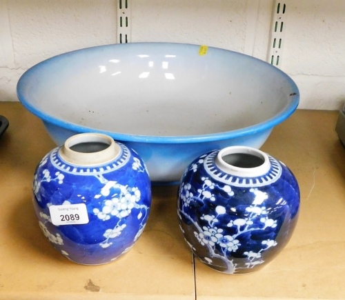 Two Oriental ginger jars, decorated with prunus against a cracked ice blue ground, lacking lids, and a wash bowl.