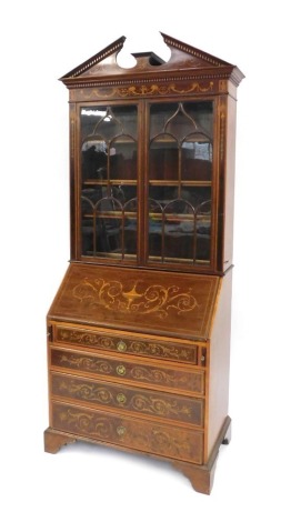 A late 19thC Sheraton revival marquetry inlaid mahogany bureau bookcase, with dentil moulded broken arch pediment, over two astragal glazed doors, the base having a fall flap resting on lopers revealing a fitted interior, over four graduated drawers, oak 