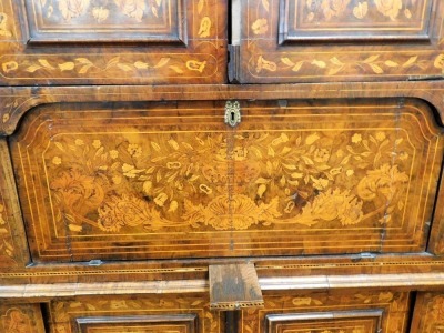 A 18thC Dutch marquetry corner cabinet, with fixed swan neck pediment, raised above heavily carved shelves and cupboard beneath, profusely decorated with leaves and flowers with a lower geometric inlay, fronted by two elaborate designed doors, 243cm high, - 3