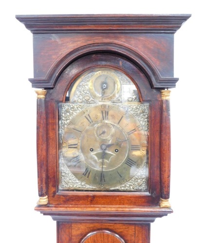 A George III longcase clock, with inset pillared hood, full length moulded trunk door and plain base, the square arch dial having silent/strike roundel to the arch, the chapter ring having Roman hour and Arabic minute numerals, enclosed by cast brass urn