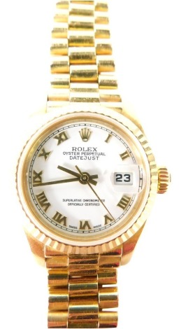 A Rolex 18ct gold cased lady's Oyster Perpetual Datejust wristwatch, Superlative Chronometer Official Certified, circular white dial bearing Roman numerals, centre seconds, date aperture, model 69178, serial number L359362, circa 1988, on an 18ct gold bra