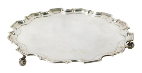 A George V silver salver, with piecrust edge and three scroll feet, maker A F Sheffield 1921 and marked ROBT. JONES & SONS LTD 10 Dale Street Liverpool, 36cm diameter, 38oz.