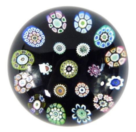 A Perthshire millefiori paperweight, on royal blue ground set with various cane clusters, 8cm diameter.