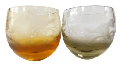 Two etched glass tumblers, smoky brown and citrine, each with birds and trees, 5cm diameter.