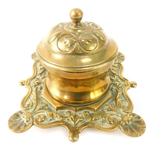 A cast brass inkwell, of heavily foliate scroll design and shell capped ends, 10cm high.