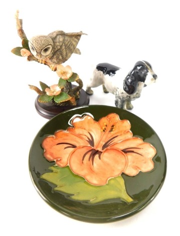 Three named ceramics, comprising a Moorcroft Peony pin dish, 12cm diameter, a Beswick Spaniel, and a Country Artists Barn Owl on branch. (3)