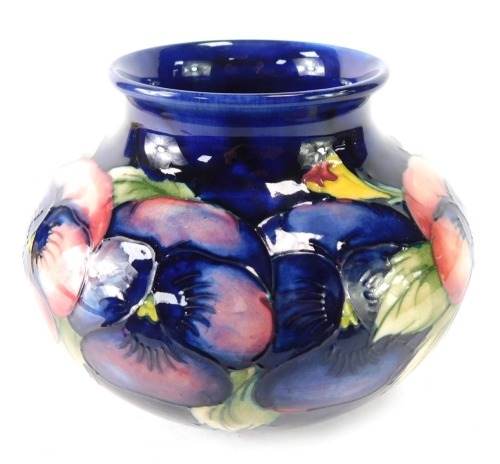 A Moorcroft vase, the flared rim top on a royal blue body, with pansy design, 12cm high.