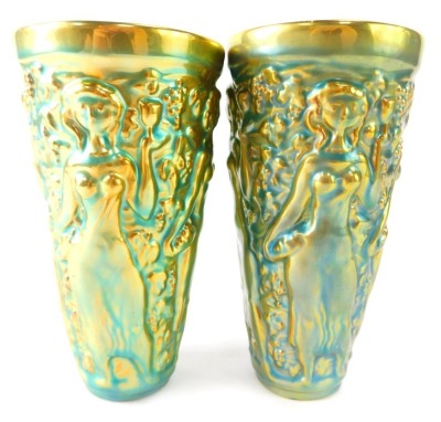 A pair of Zsolnay Hungarian lustre glazed art pottery vases, each depicting nude maidens and fruiting vines, on a blue ground heightened in gold, 15.5cm high.