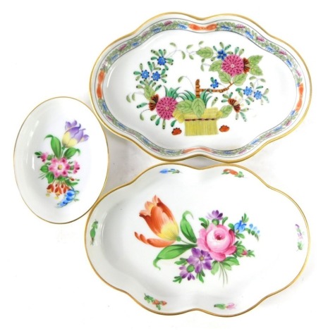 Three Herend of Hungary trinket dishes, comprising two flared rim examples, each with floral decoration, 14cm diameter, and an oval pin dish with blue bell design, 8cm diameter. Marked K2000, 7705FD & 7705BT. (3)