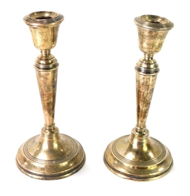 A pair of George V silver taper candlesticks, each on a weighted base, Birmingham 1919, 20cm high.