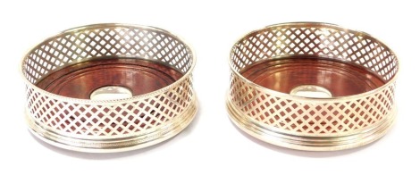 A pair of silver wine coasters, each with fret border, on mahogany base, Birmingham 1994, 12.5cm diameter.