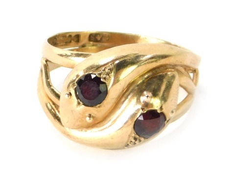 A 9ct gold snake ring, the head formed of two snake heads set with garnets, size T, 6.2g all in.