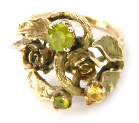 An abstract dress ring, with leaf and rose detail, set with peridot and citrine, yellow metal unmarked, size O, 8.9g all in.