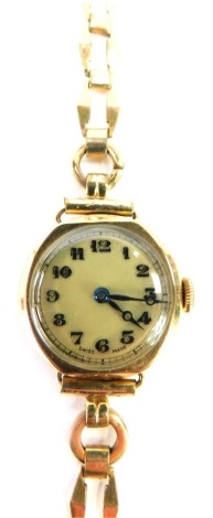 A 9ct gold lady's wristwatch, with small circular watch head and blue hands, 2cm diameter, on elongated charm bracelet, 13.8g all in.