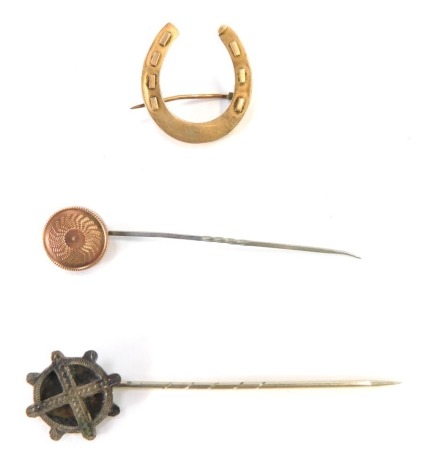 A group of jewellery, comprising a 9ct gold stick pin, a 9ct gold horseshoe brooch and a silver stick pin, 5g all in. (3)