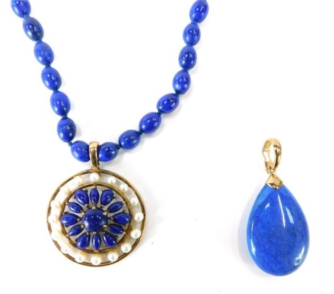 Lapis Lazuli jewellery, comprising a Lapis beaded necklace with circular pendant set with seed pearls, yellow metal marked 375, the pendant 3cm high, the chain 25cm long, together with a Lapis drop pendant, with loop clip clasp, yellow metal marked 375 to