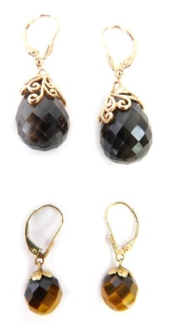 Two pairs of stone set earrings, to include a pair of rose gold and smoky quartz set drop earrings, the smoky quartz ball pendant with scroll detailing on rose gold mount, marked 375, 3.5cm drop, together with a pair of 9ct gold tiger's eye drop earrings,