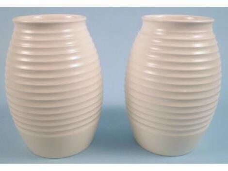 A pair of Wedgwood Keith Murray cream glazed vases with ribbed decoration