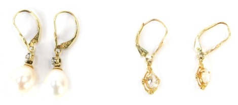 Two pairs of earrings, to include a pair of 9ct gold cultured pearl and diamond set drop earrings, 3.5cm high together with a pair of yellow metal diamond set cluster earrings, each with tiny diamond, yellow metal stamped 14kt, 3cm high, 5.2g all in.