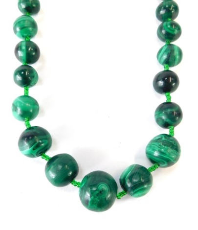 A malachite necklace, with graduated malachite beads, the largest bead 20mm the smallest 10mm wide, approximately 64cm long overall, 167.9g all in.