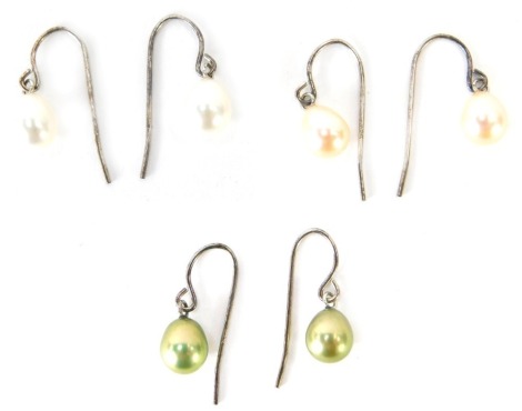 Three pairs of cultured pearl and silver drop earrings, comprising cream, peach and green lustre, 4.9g all in.