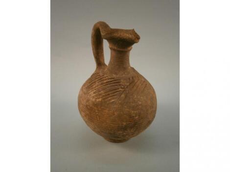 A thrown pottery ewer with scratched decoration: By repute a Persian jug from 600BC