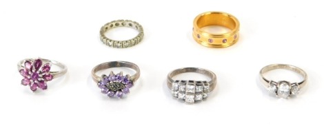 Six various dress rings, to include three silver stone set cluster rings, an unmarked eternity ring and a gold finished purple stone set eternity ring, 20.7g all in.