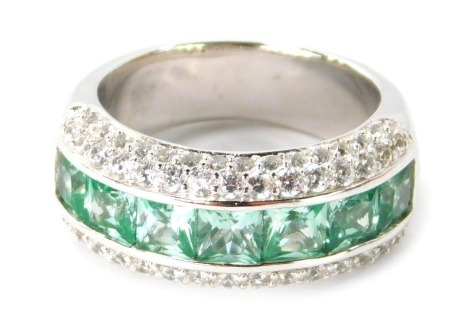 A silver CZ and green stone set half hoop eternity ring, the centre band with square cut pale green stones, an outer surround of tiny diamonds, ring size P½, 8.6g.