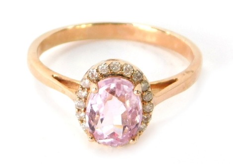 A 9ct gold dress ring, with central oval pink topaz, surrounded by CZ, on a rose gold setting, on a raised claw with splayed shoulders, ring size P½, 3g all in.