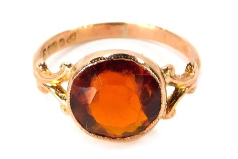 A George V 9ct gold dress ring, the central orange tourmaline in rub over outer setting, with V splayed scroll design shoulders, Chester 1916, ring size R½, 3g all in.