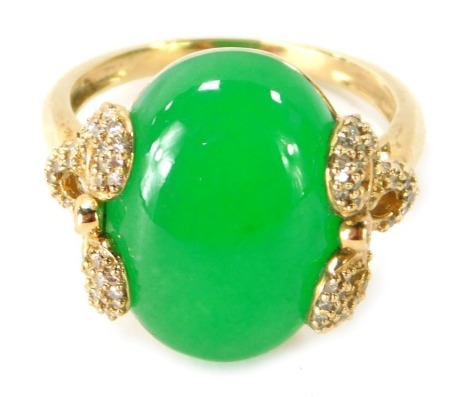 A 9ct gold jade dress ring, the central oval cut light green jade, with bow design shoulders, set with tiny diamonds, ring size P½, 6.7g all in.