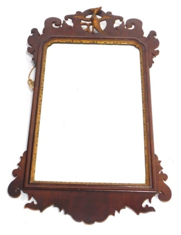 A fret framed mahogany wall mirror in George III style, with gilt ho-ho bird and scroll shaped crest, 73cm high, 41cm wide.