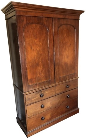 An early Victorian mahogany linen press, with moulded cornice and two arched panel doors, revealing a hanging interior over two short and two long graduated drawers with knob handles, 210cm high, 137cm wide, 52cm deep.