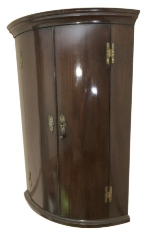 A George III mahogany bow front hanging corner cupboard, 105cm high.