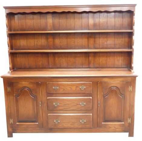 A late 20thC oak dresser, the two shelved dresser top on sideboard base, with two cupboards and three drawers on stiles, 175cm high, 172cm wide, 43cm deep.