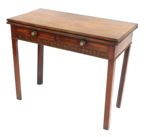 A George III mahogany tea table, with fold over top above two drawers with carved supports on tapered legs, 74cm high, 90cm wide, 45cm deep.