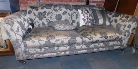 A Duresta style two seater sofa, in charcoal grey with floral sprays, 230cm wide, 70cm high, 100cm deep.