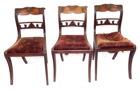 A set of three Irish Regency mahogany dining chairs, with carved bar backs, drop in seats and sabre legs. (3) (AF)