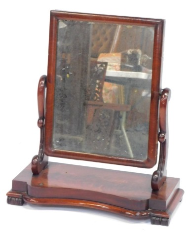 A Victorian flame mahogany dressing table mirror, with rectangular plate, scroll supports, and stepped serpentine base, 70cm high, 72cm wide.