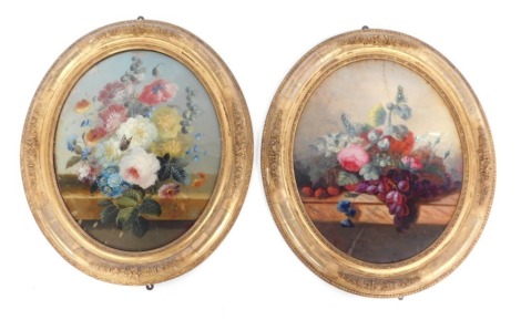 A pair of Victorian reverse painted glass panel pictures, each oval with floral still life, in ornate gilt frames, 46cm x 36cm. (AF)